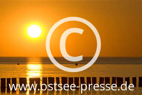 Die Sonne wirft einen langen glitzernden Streifen auf die Ostsee, bis sie am Horizont scheinbar im Meer versinkt...