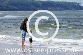Strandspaziergang an der Ostsee - Mama und Tochter testen mit den Füßen, wie warm das Ostseewasser heute ist.